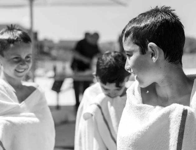 ילדים צוחקים עטופים במגבות אחרי יום קיץ צילום משפחתי טבעי ודוקומנטרי מאת טל גולדשטיין